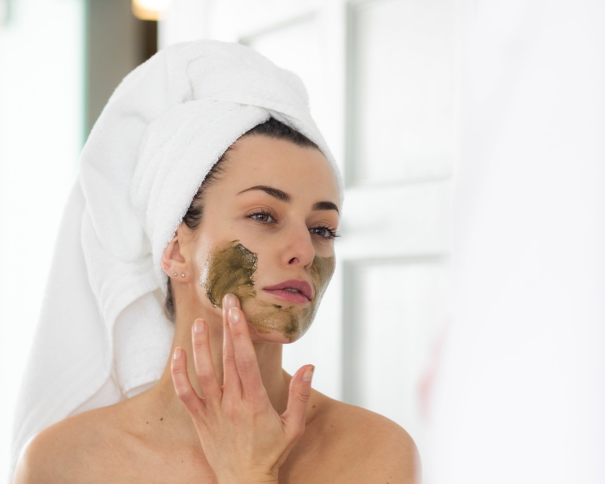 Applying Inlight Superfood Mask. Texture of exfoliating green face mask. Model with white turban, organic skincare