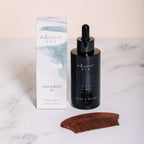 Inlight Men's Organic head and beard oil with a wooden comb on a marble surface