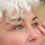 Inlight Organic Under Eye Revive Balm for tired, fatigued eyes. Model using eye balm