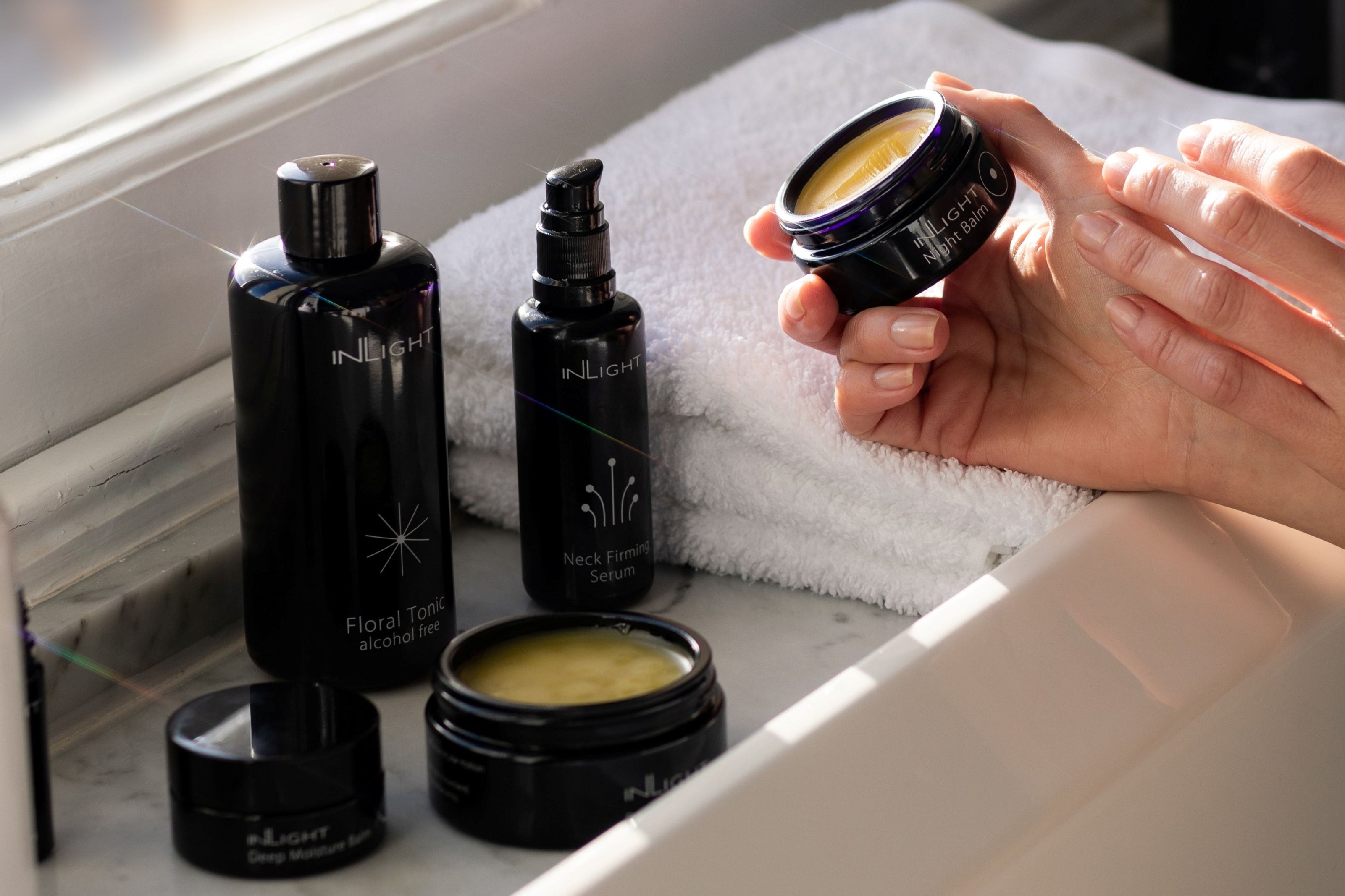 Inlight Beauty Organic Balms and oils on a sunlit windowsill. Still life product photography style